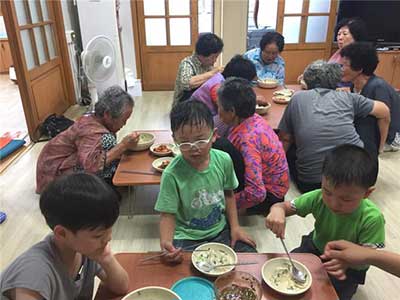 마을어른들과 함께 콩국수를 먹는 아이들. 